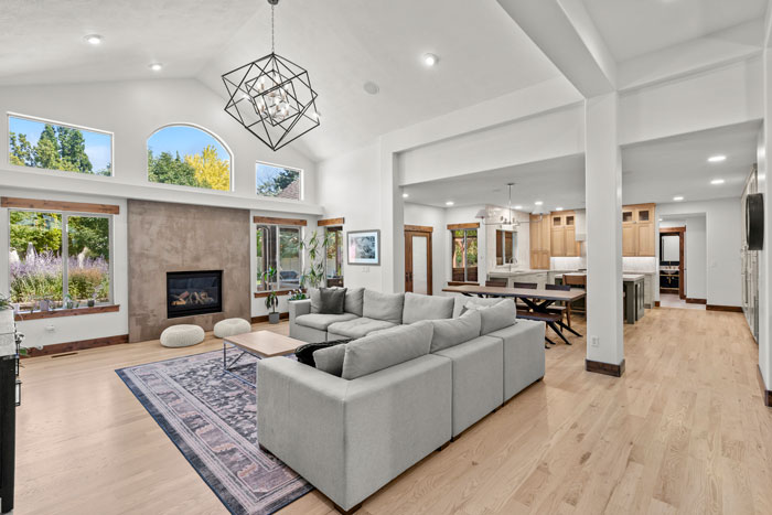 Bright open remodeled living area with large kitchen in background