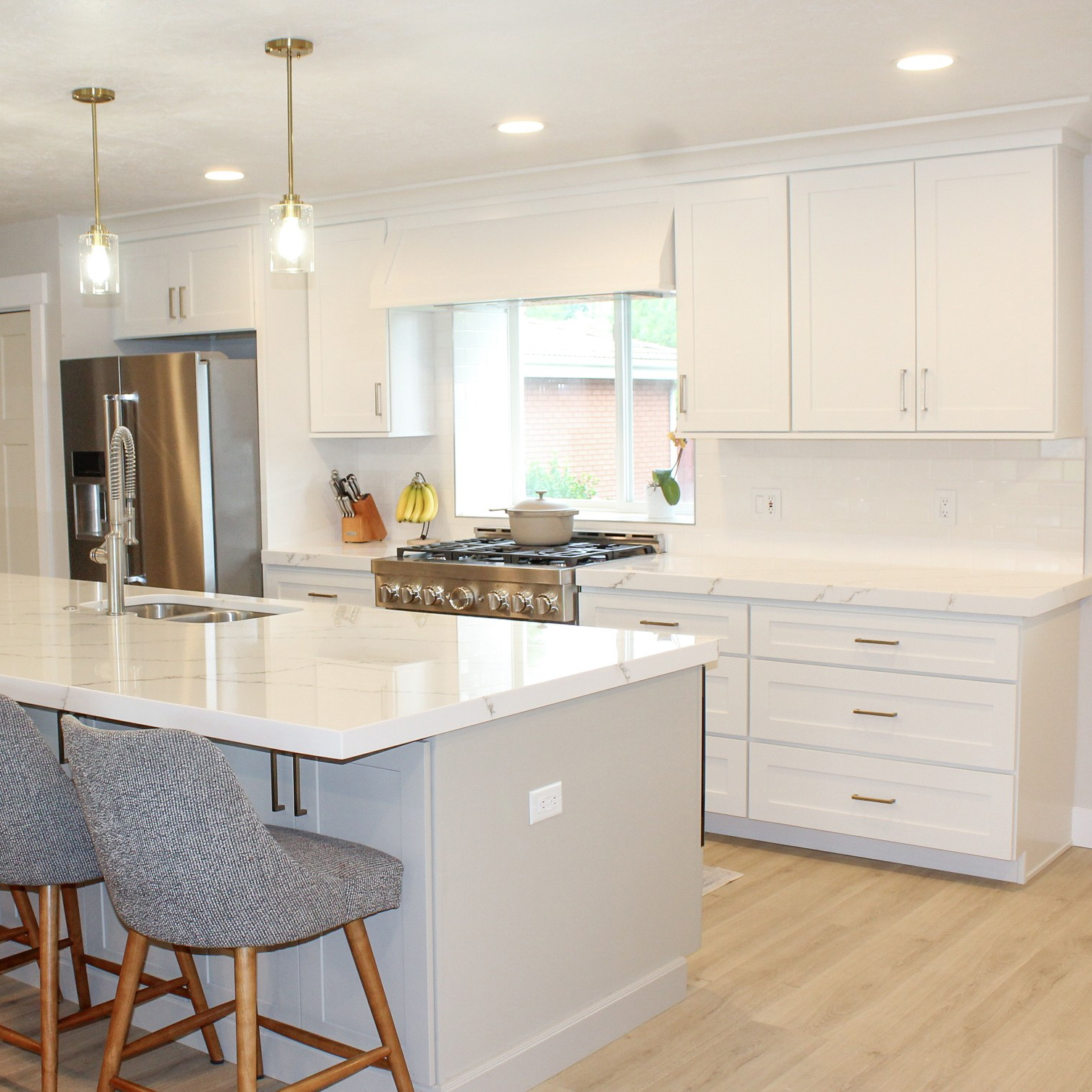 Beautiful Two Tone Kitchen by Utah Home Remodel, featuring primarily white cabinets and a navy blue island.